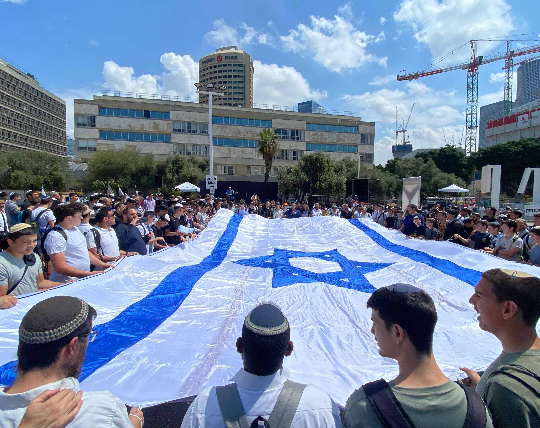 התלמידים מחזיקים בדגל ישראל ענק שהכינו